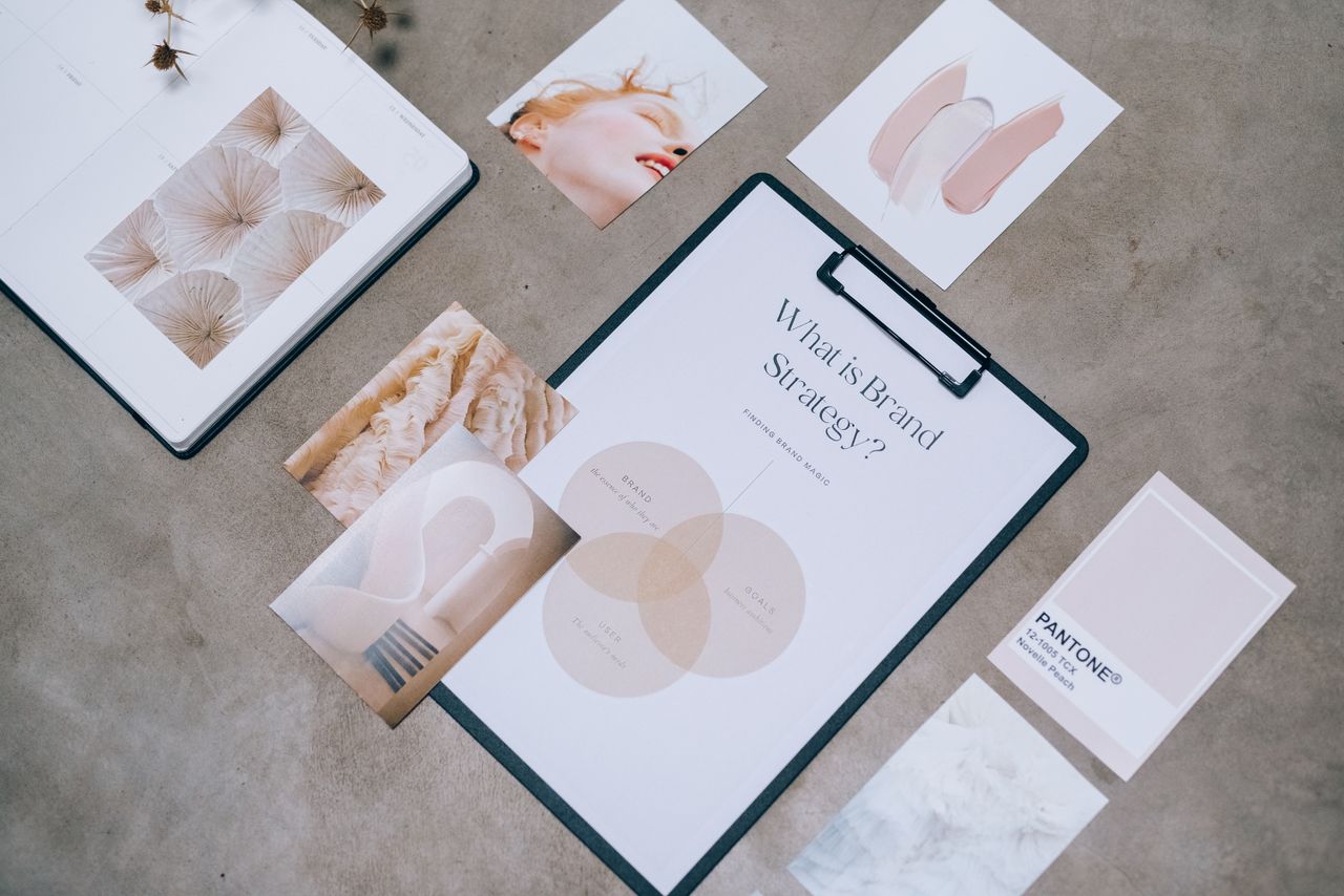 Brand guideline pages laid out on a desk